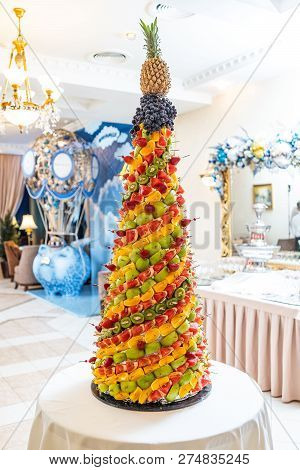 Tropical Fruits Cut Thtower Of Chopped Tropical Fruits And Strawberries At The Banquet. Appetizer At