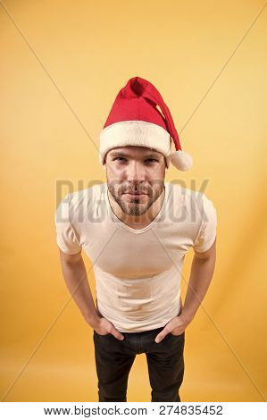 Man Look With Squinty Eyes In Red Santa Hat And White Tshirt On Orange Background. Santa Claus Fashi