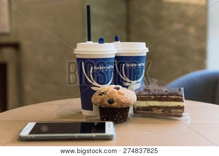 Chengdu, Sichuan Province, China - Dec 14, 2018 : Luckin Coffee Cup With Muffin, Black Forest Cake A