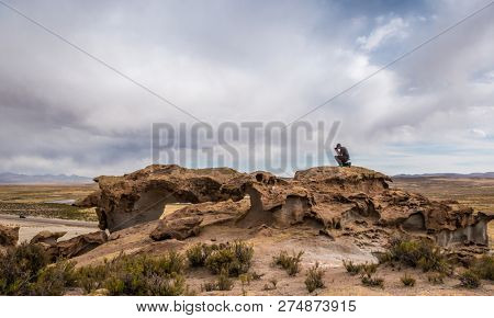 Amazing scenery of mountanious Bolivian landscape and man taking photo at the rocks