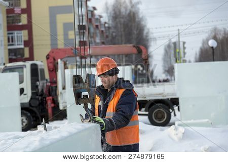 Slinger In An Orange Helmet On Unloading Ice Blocks