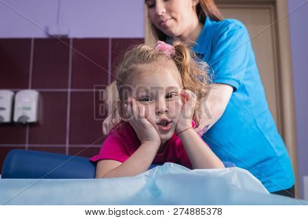 Physiotherapy With Child With Cerebral Palsy. A Little Girl Lays On The Couch