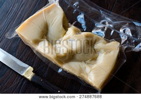 Turkish Traditional Gravyer / Gruyere Cheese In Package From Kars On Wooden Surface.
