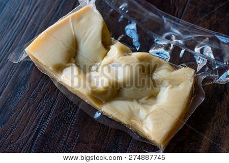 Turkish Traditional Gravyer / Gruyere Cheese In Package From Kars On Wooden Surface.