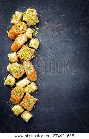 Traditional Oriental baklava collection as top view on a black board with copy space right 