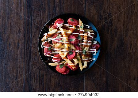 Homemade Peruvian Salchipapa Fries With Sausage Slices, Ketchup And Mayonnaise.