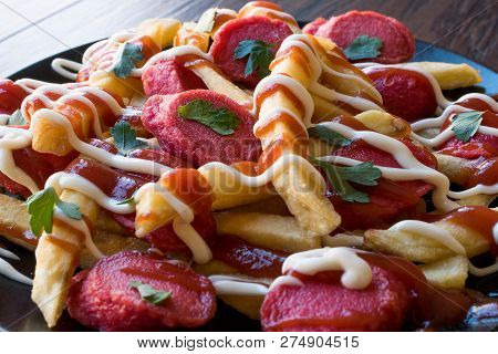 Homemade Peruvian Salchipapa Fries With Sausage Slices, Ketchup And Mayonnaise.