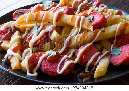 Homemade Peruvian Salchipapa Fries With Sausage Slices, Ketchup And Mayonnaise.