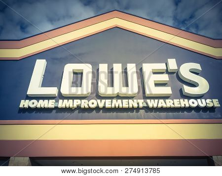 Close-up Logo Of Lowe’s Hardware Store Entrance Under Cloud Blue Sky