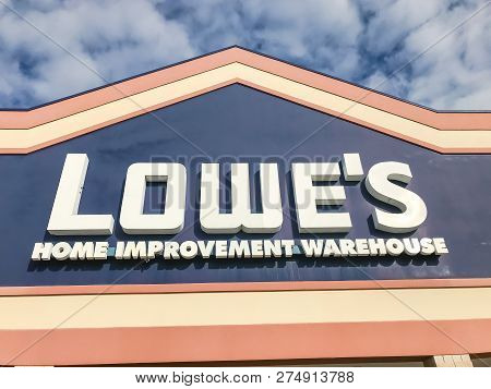 Close-up Logo Of Lowe’s Hardware Store Entrance Under Cloud Blue Sky