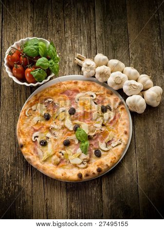Pizza capricciosa op schotel op hout achtergrond