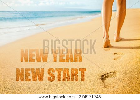 New Year 2019 New Start resolution concept. Beach woman legs feet walking barefoot on sand leaving footprints in sunset. Vacation travel freedom people.