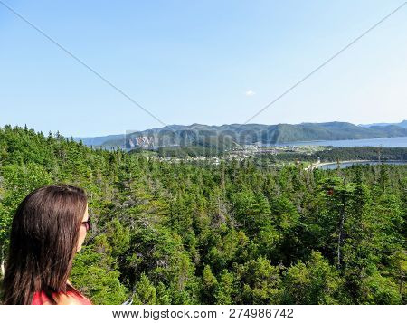 A Young Female Tourist Admiring The View Of Neddy And Rocky Harbour, Norris Point, And Bonne Bay Ove