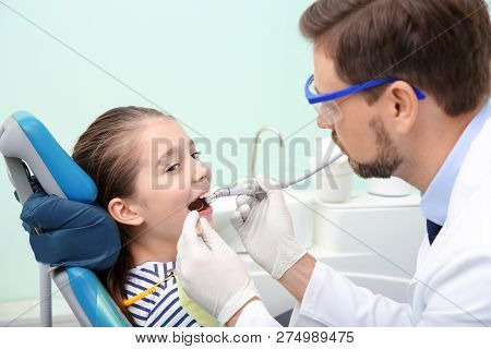 Professional Dentist Working With Little Patient In Modern Clinic