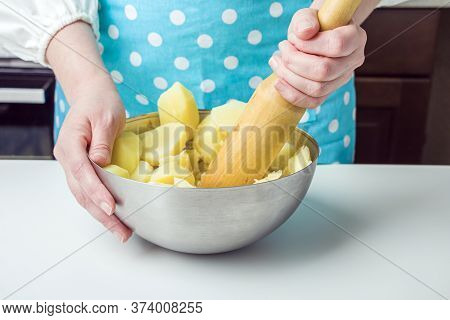 Cooking Potato Pie Fillings (quiche, Dumplings). Female Hands Hold A Wooden Potato Masher In The Hom