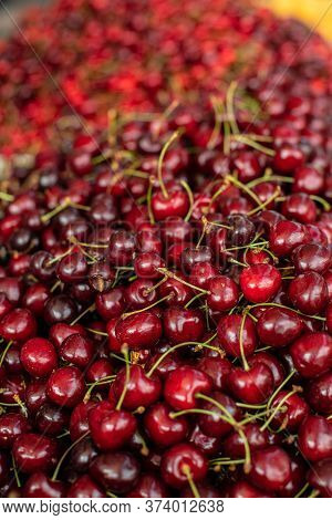Close Upu Picture Of A Lot Of Burgundy, Red Cherries Sold On The Market. Fruit Market