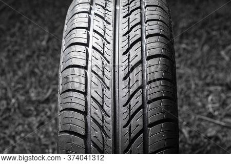 Car Tire In Dark Color. Night Shooting. The Tread Is Summer. Light Falls From Above