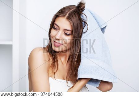 Young Beautiful Woman After Spa Treatments For Hair Care Wipes Hair With A Towel