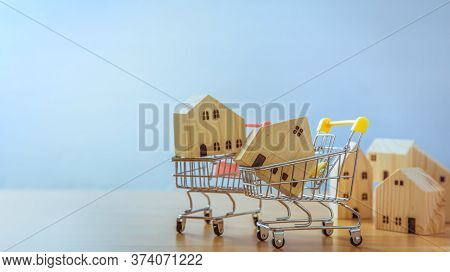 Wooden House In Cart On Wooden Desk. Saving Plan For Residence Of People In Society. Purchasing Home