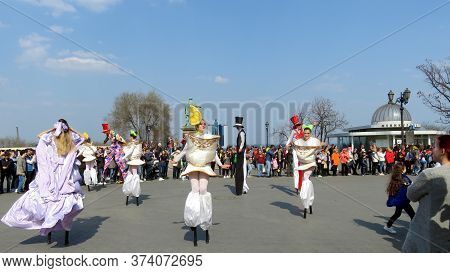 Odessa, Ukraine - 04 01 2019: Doll Princesses And Clowns Perform On Stilts In Front Of A Crowd Of Pe