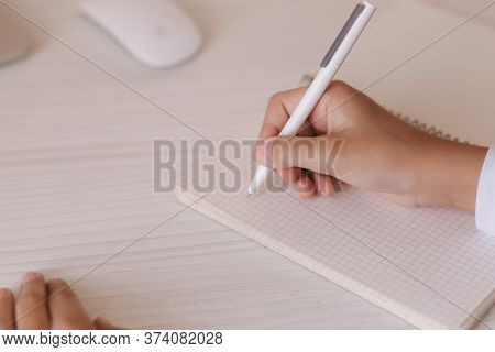 Schoolboy Study At Desk In His Room. Boy Use Laptop And Writing In Notebook. Books And Tablet On The
