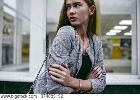 Girl In Grey Suit Posing In Front Of The Show-window