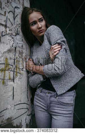Girl In Grey Suit Posing Beside Grey Wall