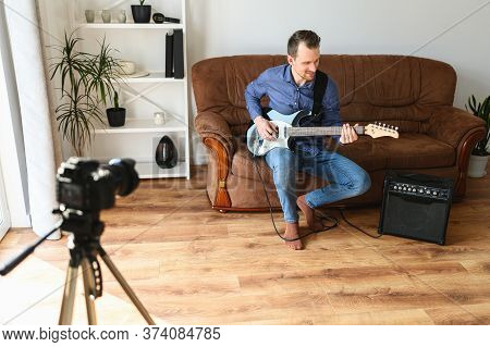 Young Man Records Tutorial Video How To Play Electric Guitar, The Camera On A Tripod Indoors, Combo 