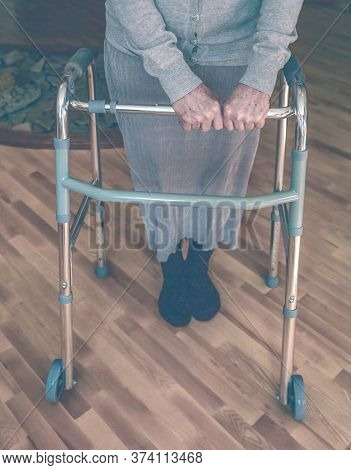 Old Wrinkled Hands On Walking Frame. Hands Of A Standing Senior Woman Leaning On A Rollator. Pension