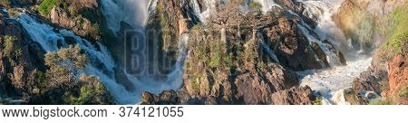 A Stitched Panorama Of Part Of The Epupa Waterfalls In The Kunene River. Baobab Trees Are Visible