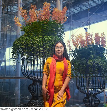 Asian Girl Posing In Front Of The Metalworks With Flowers