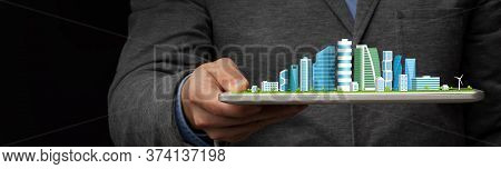Futurisitc City Plan. Unrecognizable Businessman Holding Digital Tablet With Modern Cityscape Over B