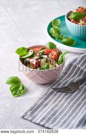 Summer Salad Of Fresh With Basil Vegetables Served In A Bowl. A Tomato. Cucumbers, Onions, Radishes.