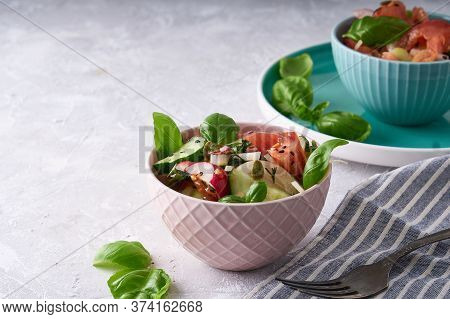 Summer Salad Of Fresh With Basil Vegetables Served In A Bowl. A Tomato. Cucumbers, Onions, Radishes.