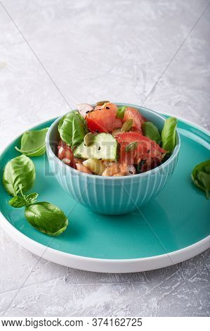 Summer Salad Of Fresh With Basil Vegetables Served In A Bowl. A Tomato. Cucumbers, Onions, Radishes.