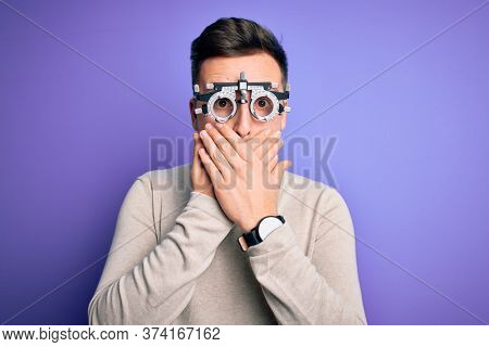 Young handsome caucasian man wearing optometrical glasses over purple background shocked covering mouth with hands for mistake. Secret concept.