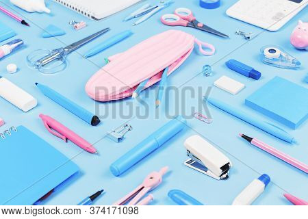 Assorted Office And School Pink White And Blue Stationery Supplies On Bluel Background. Top View Wit