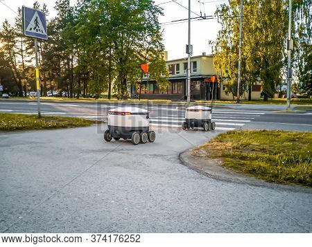 Some Delivery Robots On The Street. Estonian Cyber-couriers In Tallinn City. Sunny Summer Day. Copy 