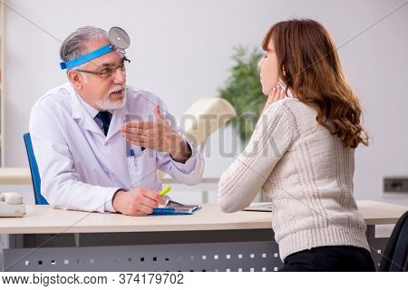 Young woman visiting old male doctor otorhinolaryngologist
