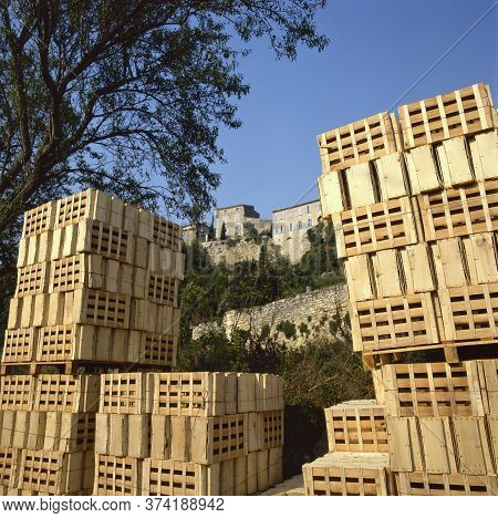 Wooden Boxes Waiting For Freshly Harvested Grapes In A Vineyard.at The Background A Small Village Ca