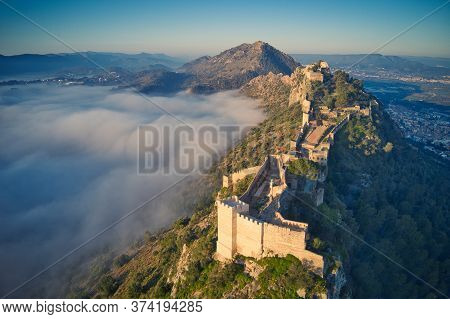 Aerial View Of Medieval Castle On A Hill. Over Fog.