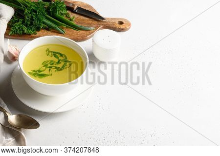 Chicken Broth With , Greens, Garlec, Parsley, Onion In White Bowl On White Table. Copy Space. Close 
