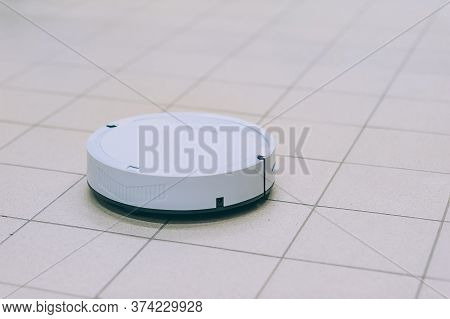 Smart Robot Vacuum Cleaner On A Tile Floor.