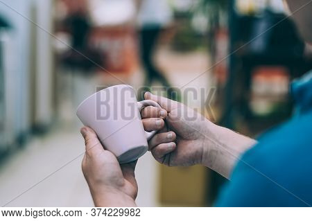 Mockup Mug In A Man Hand, Against The Background Of Shop Windows.