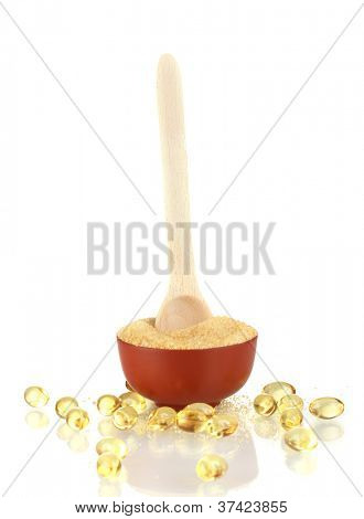 Gelatin in a bowl and wooden spoon on white background close-up
