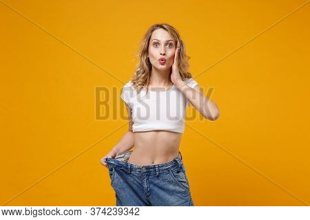 Amazed Young Woman In White T-shirt Isolated On Orange Background. Proper Nutrition Losing Weight He