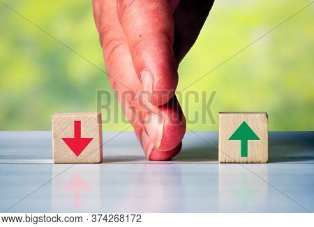 The Hand Separates Two Wooden Blocki With Red Arrow Down And Green Arrow Up. Symbol For The Differen