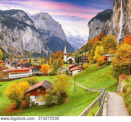 Amazing Autumn Landscape Of Touristic Alpine Village Lauterbrunnen With Famous Church And Staubbach 