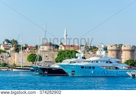 Yachts And Boats In Rhodes Port With Rhodes Fortress At Background, Greece