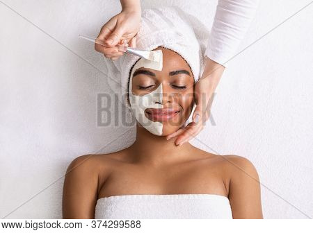 Black Woman Having White Clay Mask On Half Of Her Face, Top View